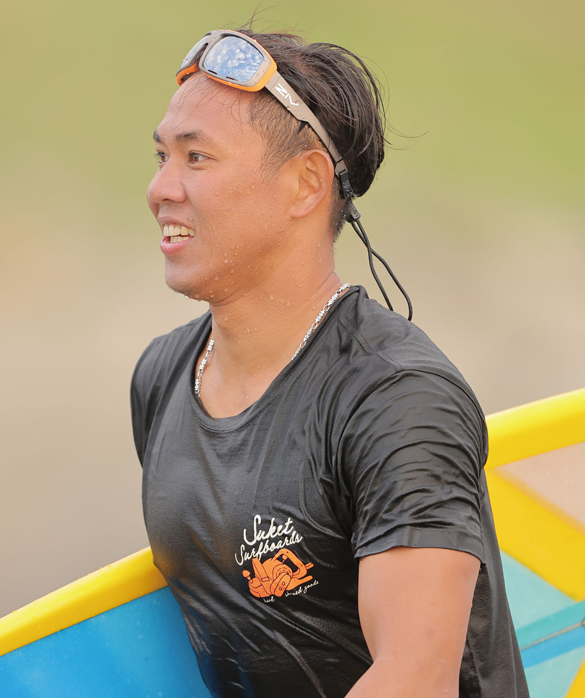男性配戴FENIX系列水上運動太陽眼鏡拿黃色衝浪板