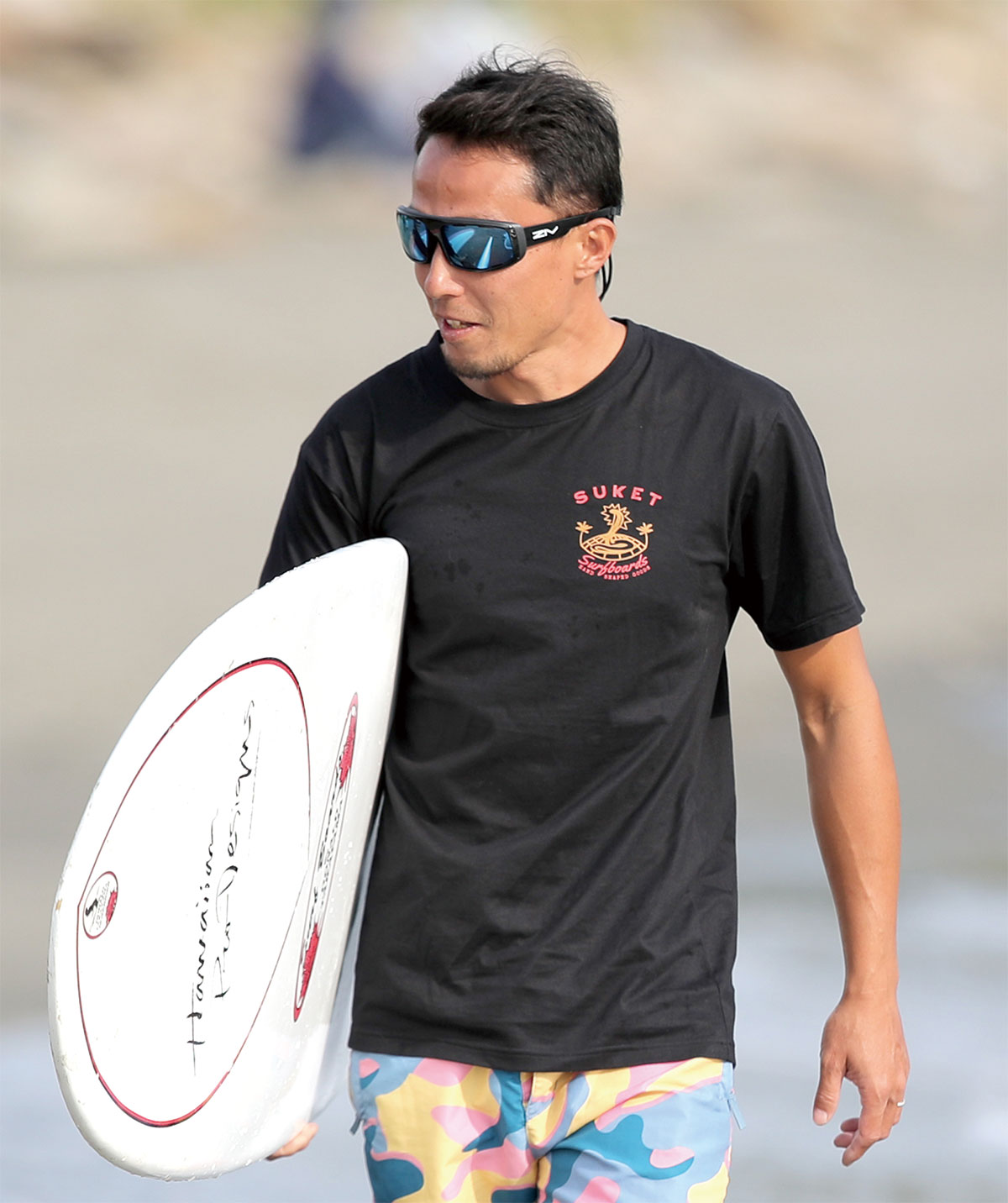 男性配戴FENIX系列水上運動太陽眼鏡拿白色衝浪板