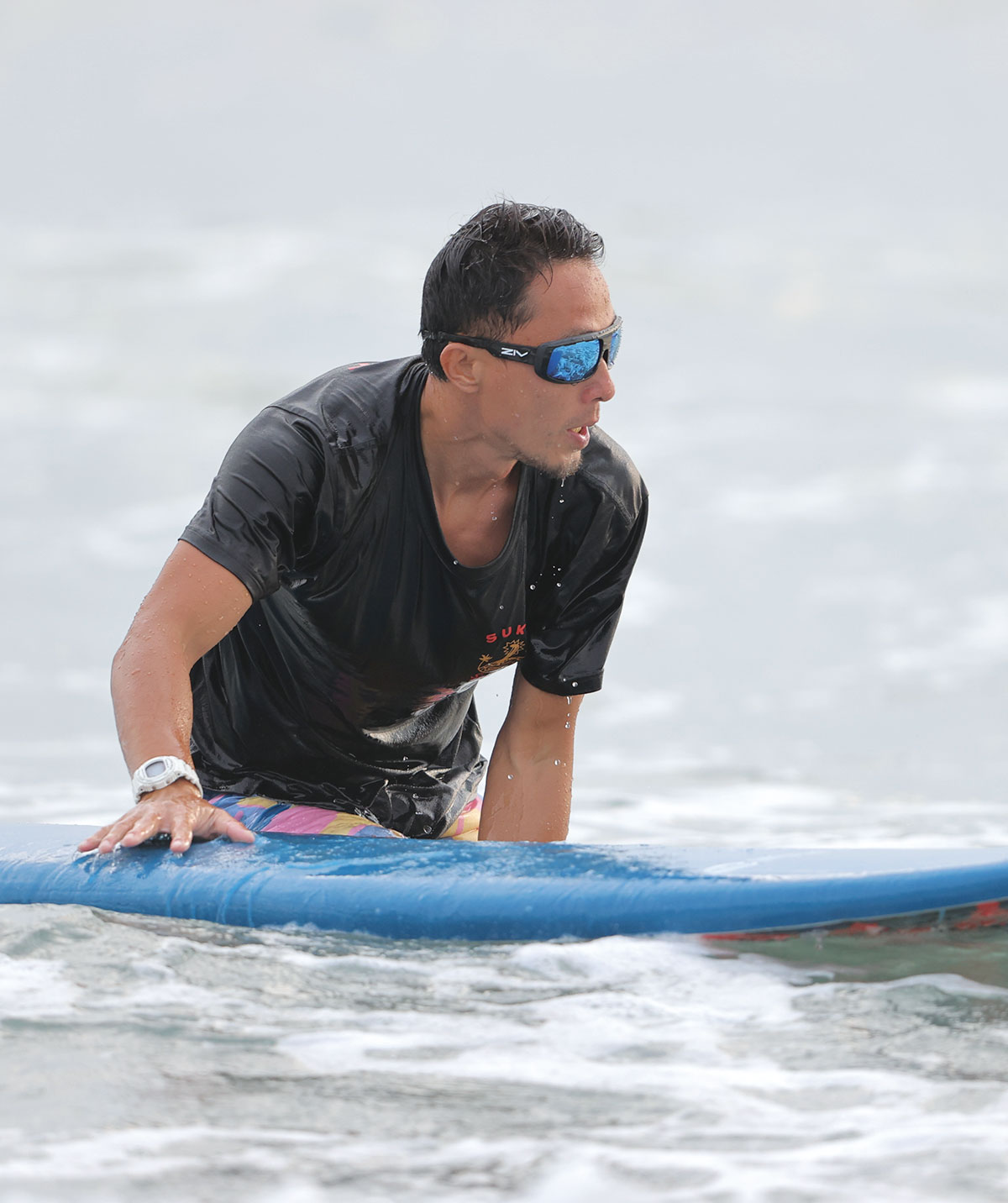 男性配戴FENIX系列水上運動太陽眼鏡拿白色衝浪