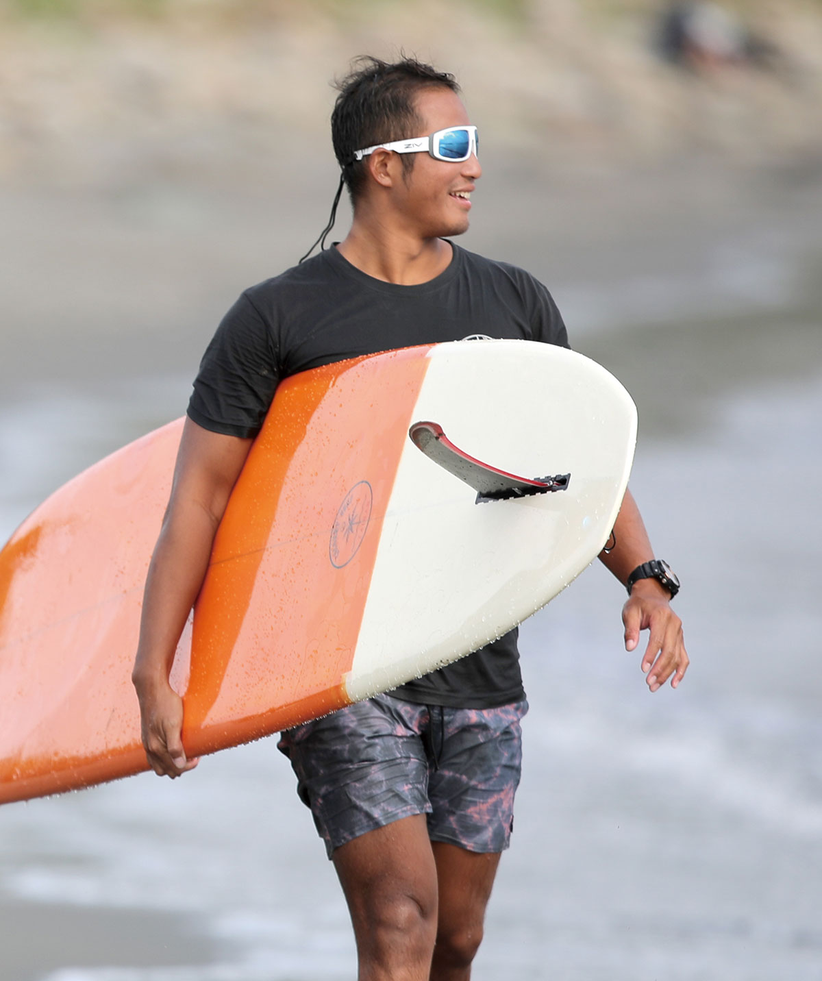 男性配戴FENIX系列水上運動太陽眼鏡拿橘白色衝浪板
